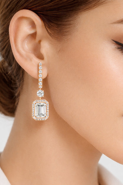 White gold emerald cut diamond dangle earrings styled on ear #wearthelook