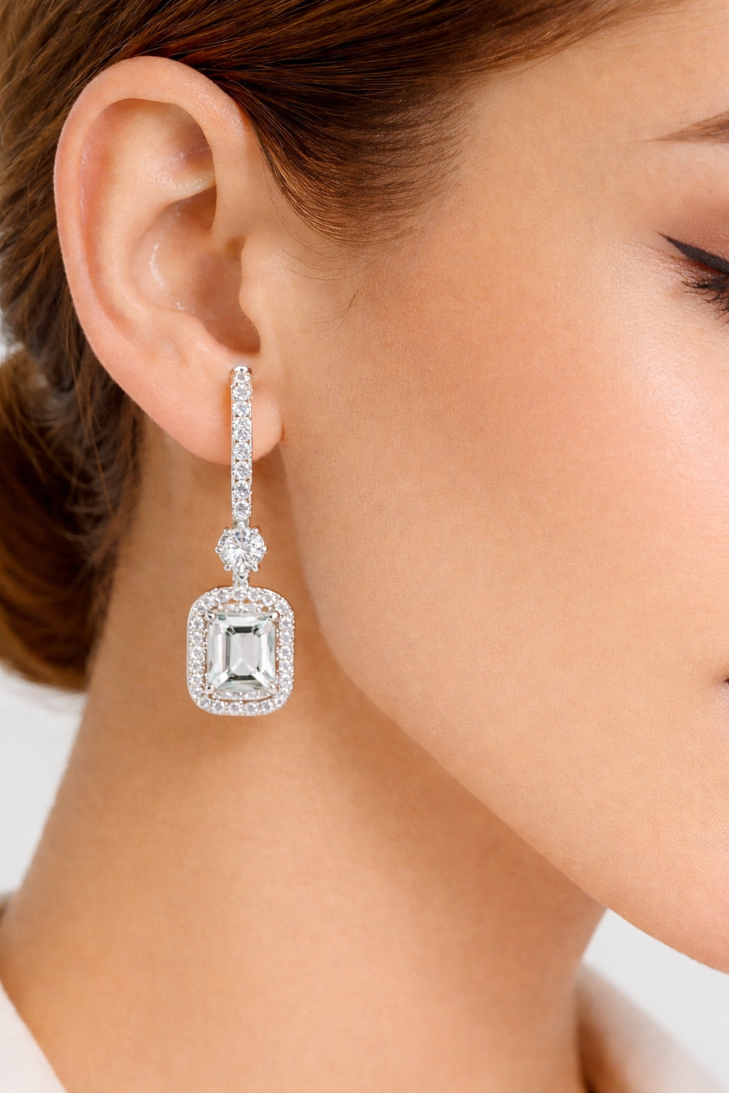 Emerald cut halo drop earrings worn on ear with white gold finish #wearthelook
