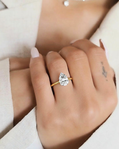 Hand wearing pear shape solitaire lab diamond engagement ring