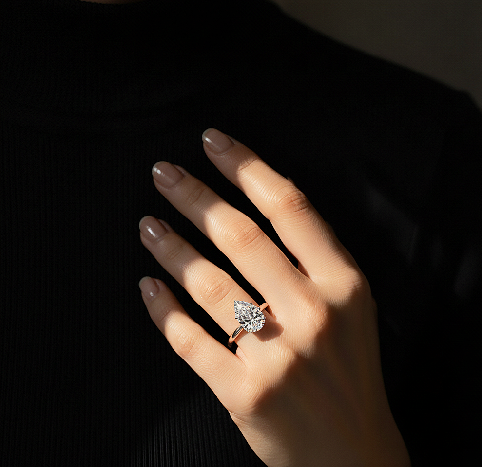 Hand wearing pear shape solitaire lab grown diamond ring