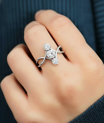 Hand wearing round cut three stone diamond ring with open infinity band style #wearthelook