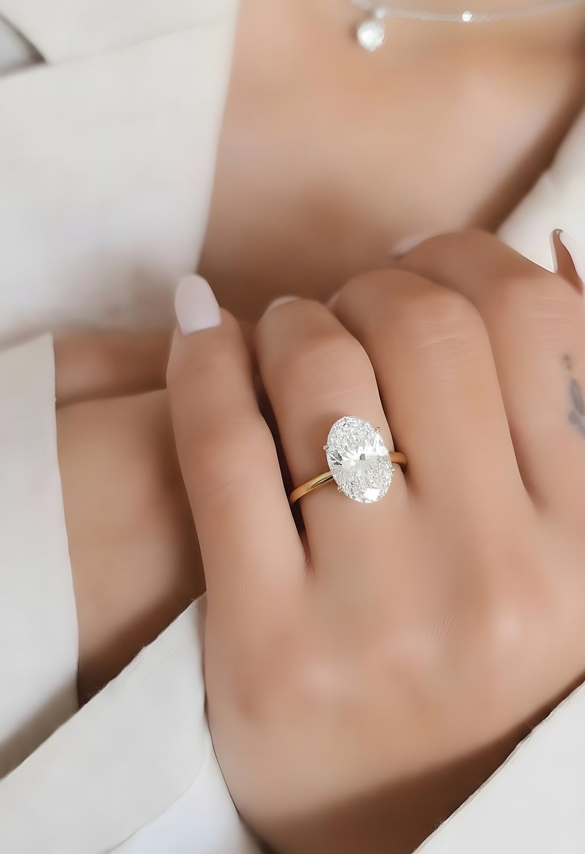Angled view of oval cut diamond solitaire ring with polished finish